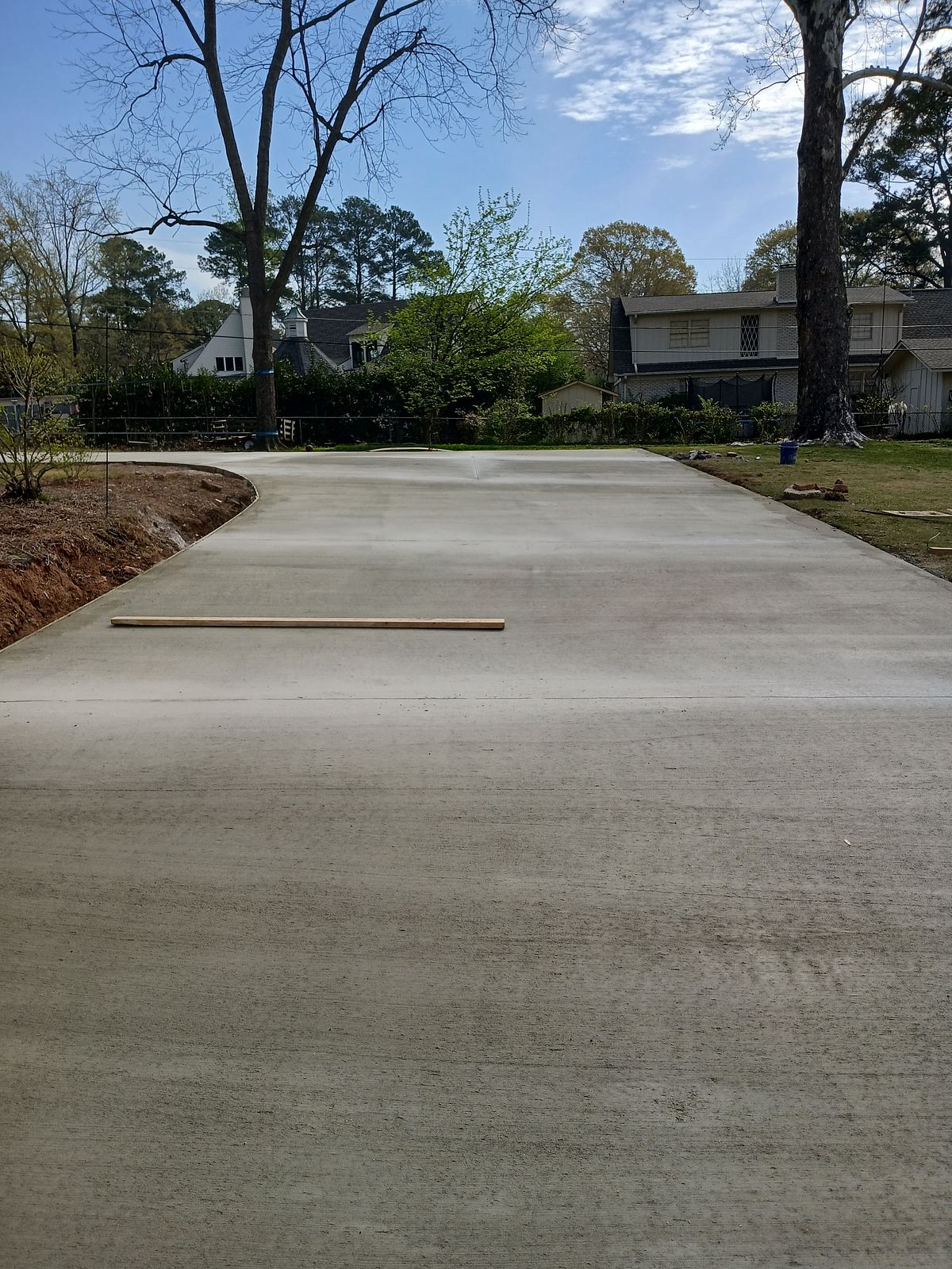 Finished concrete slab with control joints and screed board in a residential yard